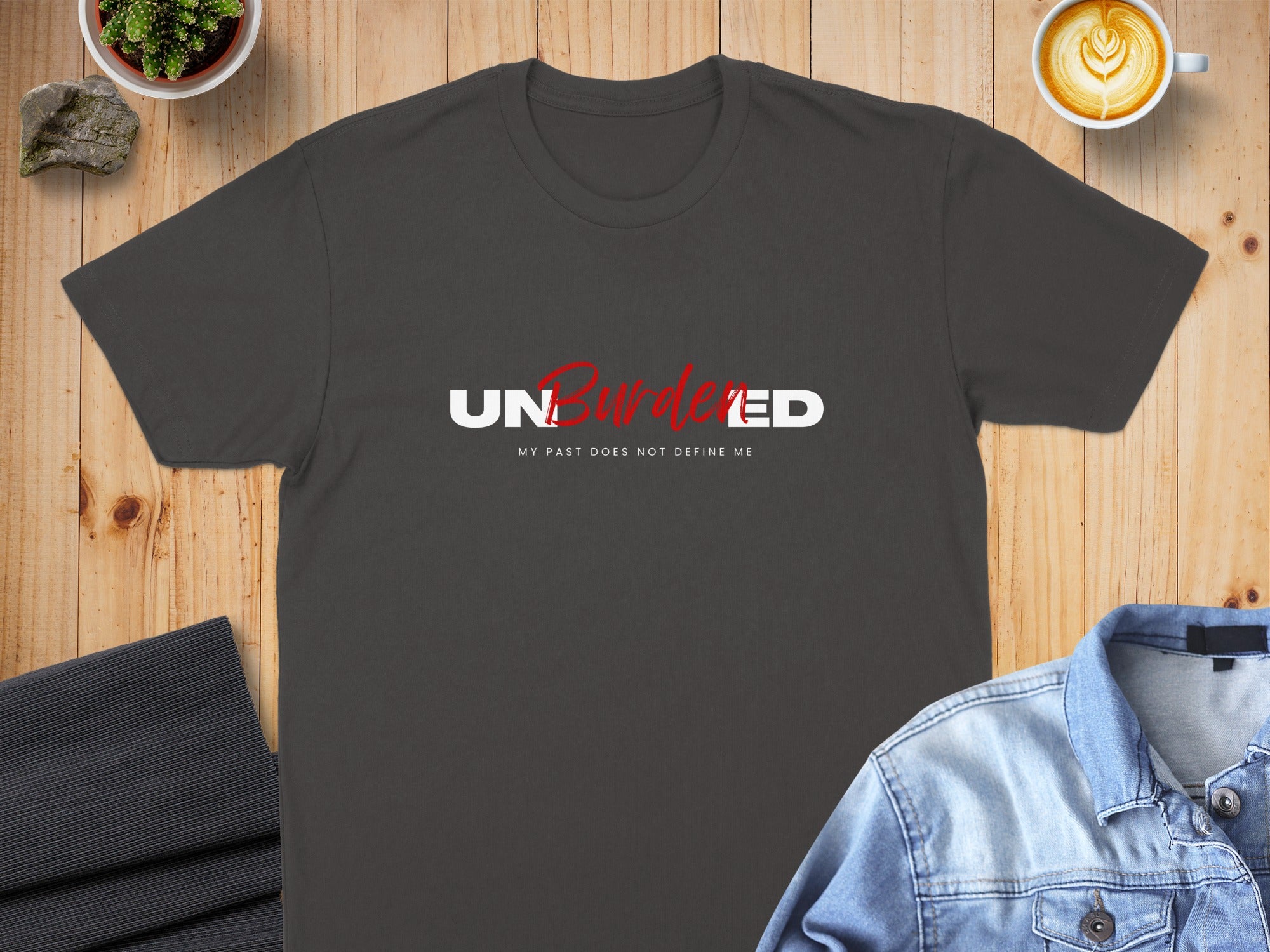Dark grey t-shirt with "UN-BURDENED" and "MY PAST DOES NOT DEFINE ME" text.