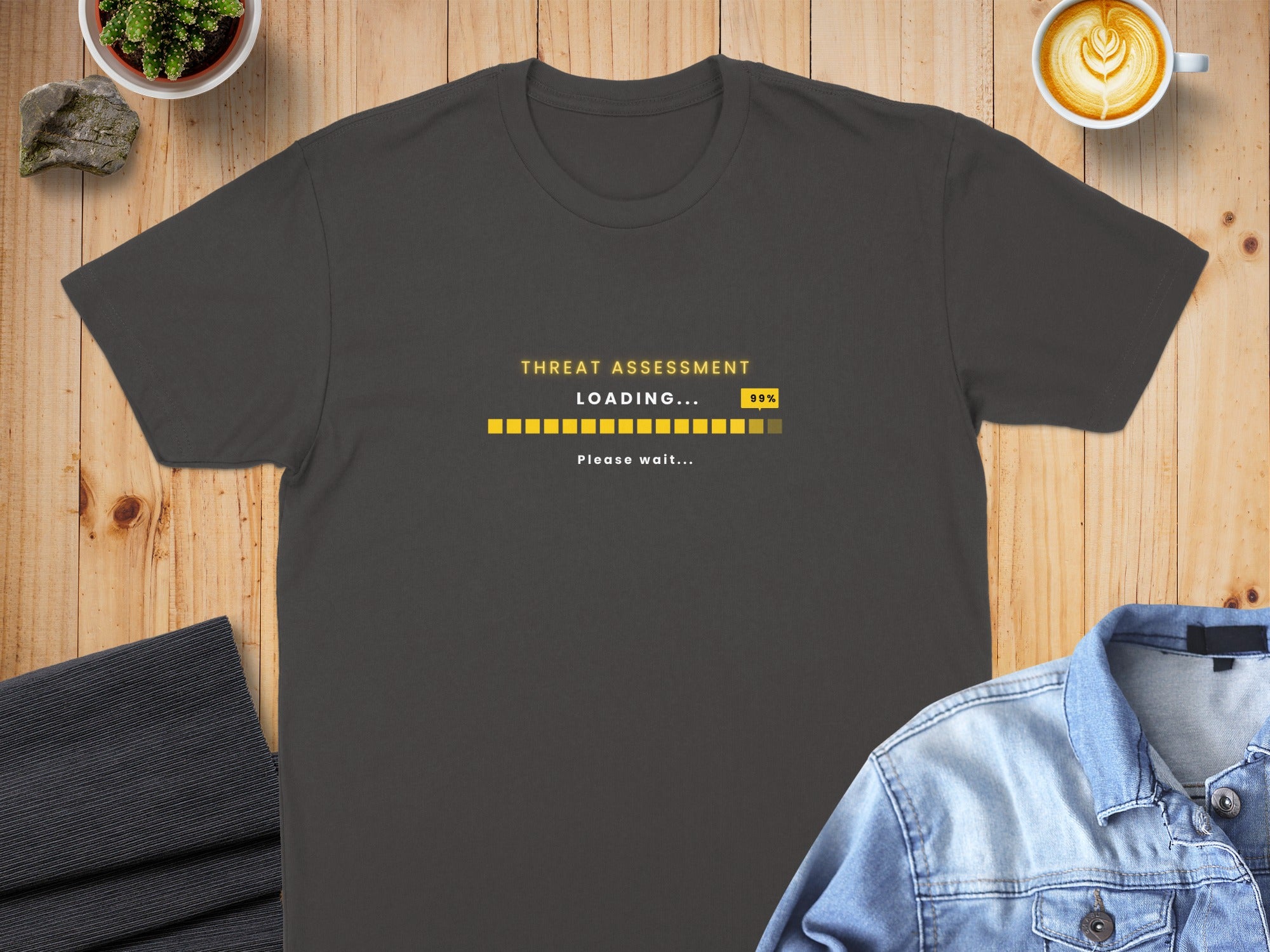 Dark grey t-shirt with "THREAT ASSESSMENT LOADING... 99% Please wait..." text.