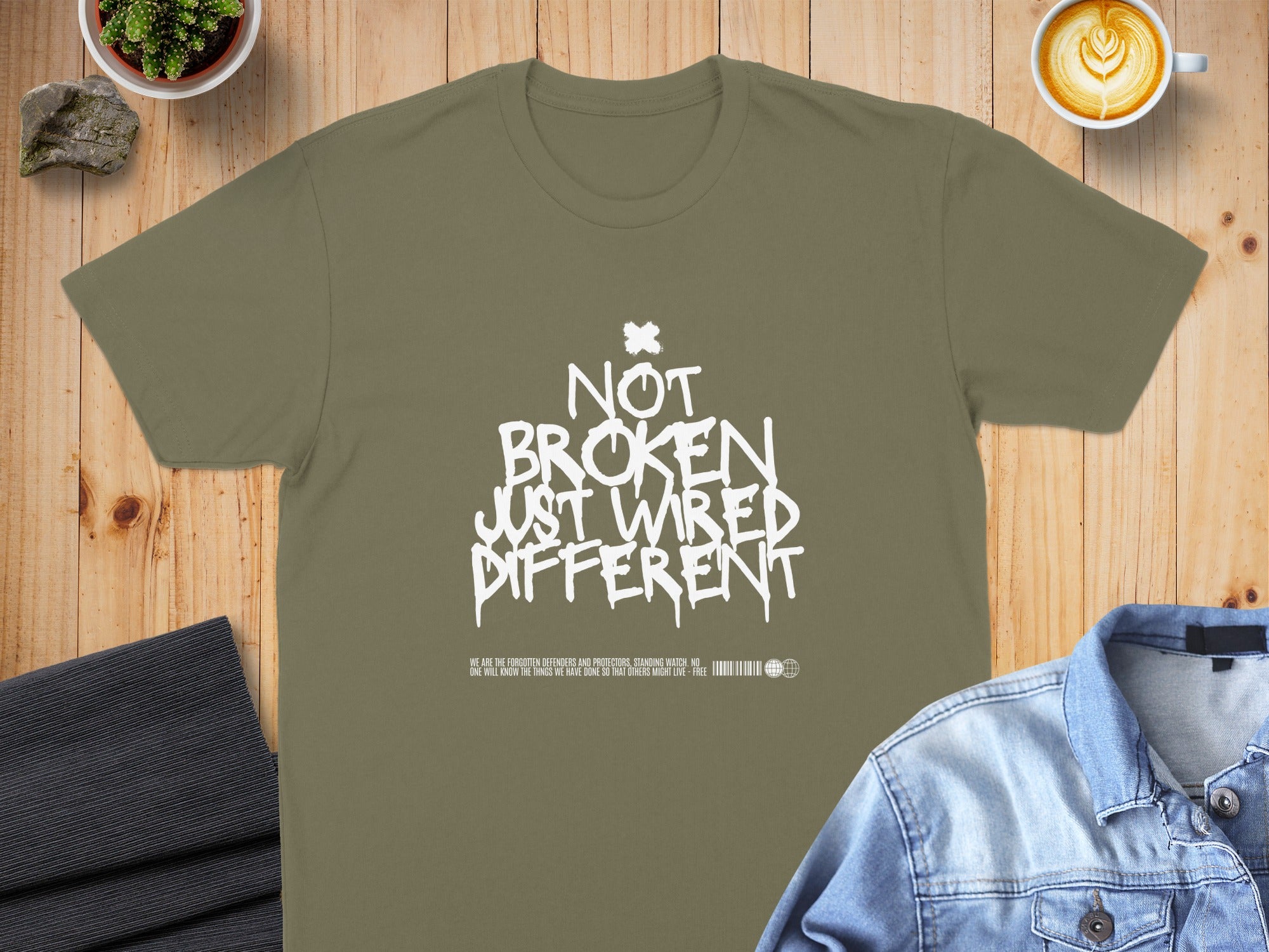 Olive green t-shirt with white distressed text "NOT BROKEN JUST WIRED DIFFERENT."