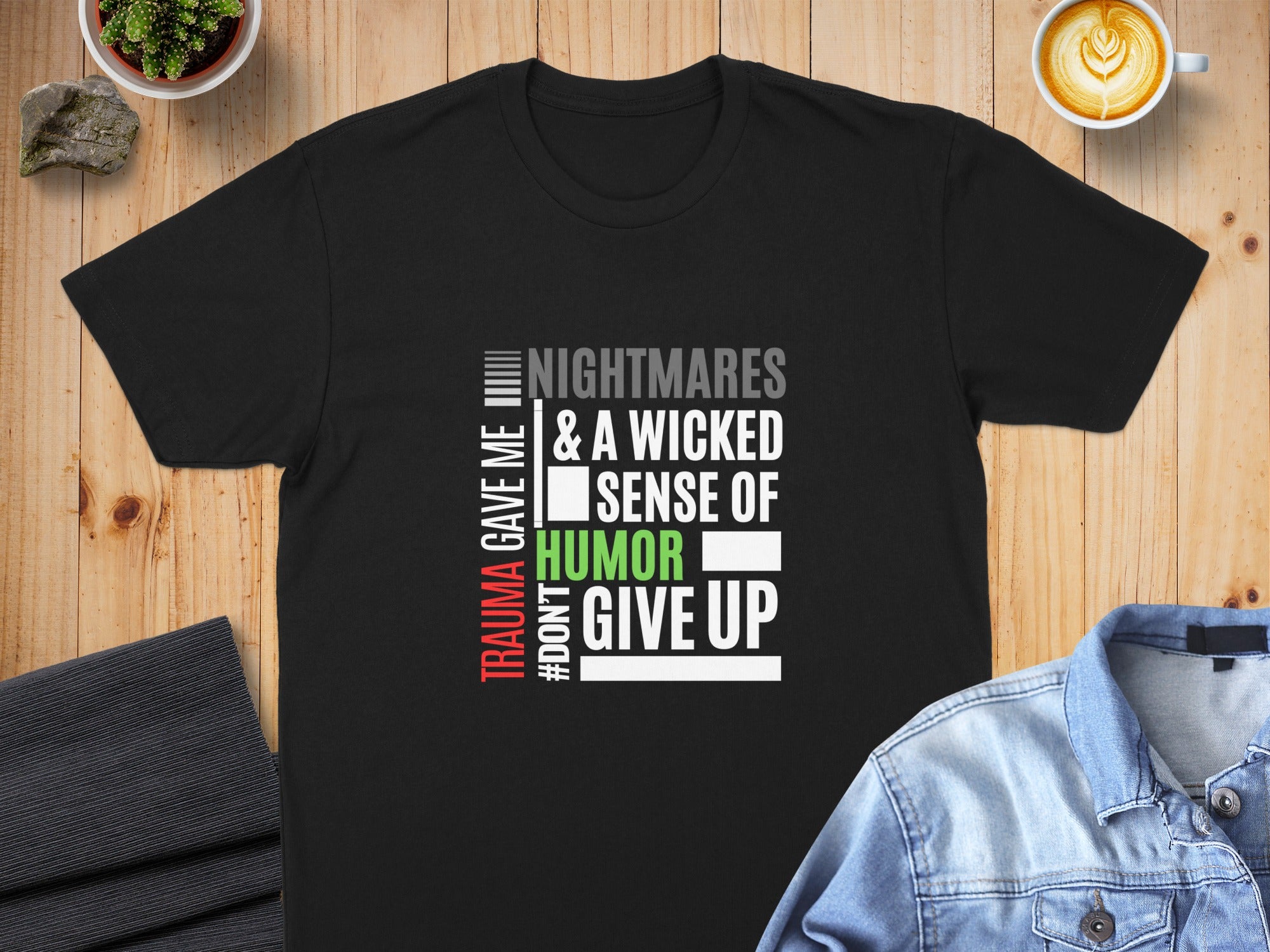 Black t-shirt with text "TRAUMA GAVE ME NIGHTMARES & A WICKED SENSE OF HUMOR #DON'T GIVE UP".