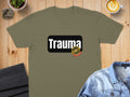 Olive t-shirt with "Trauma" text and a red and gold seal.