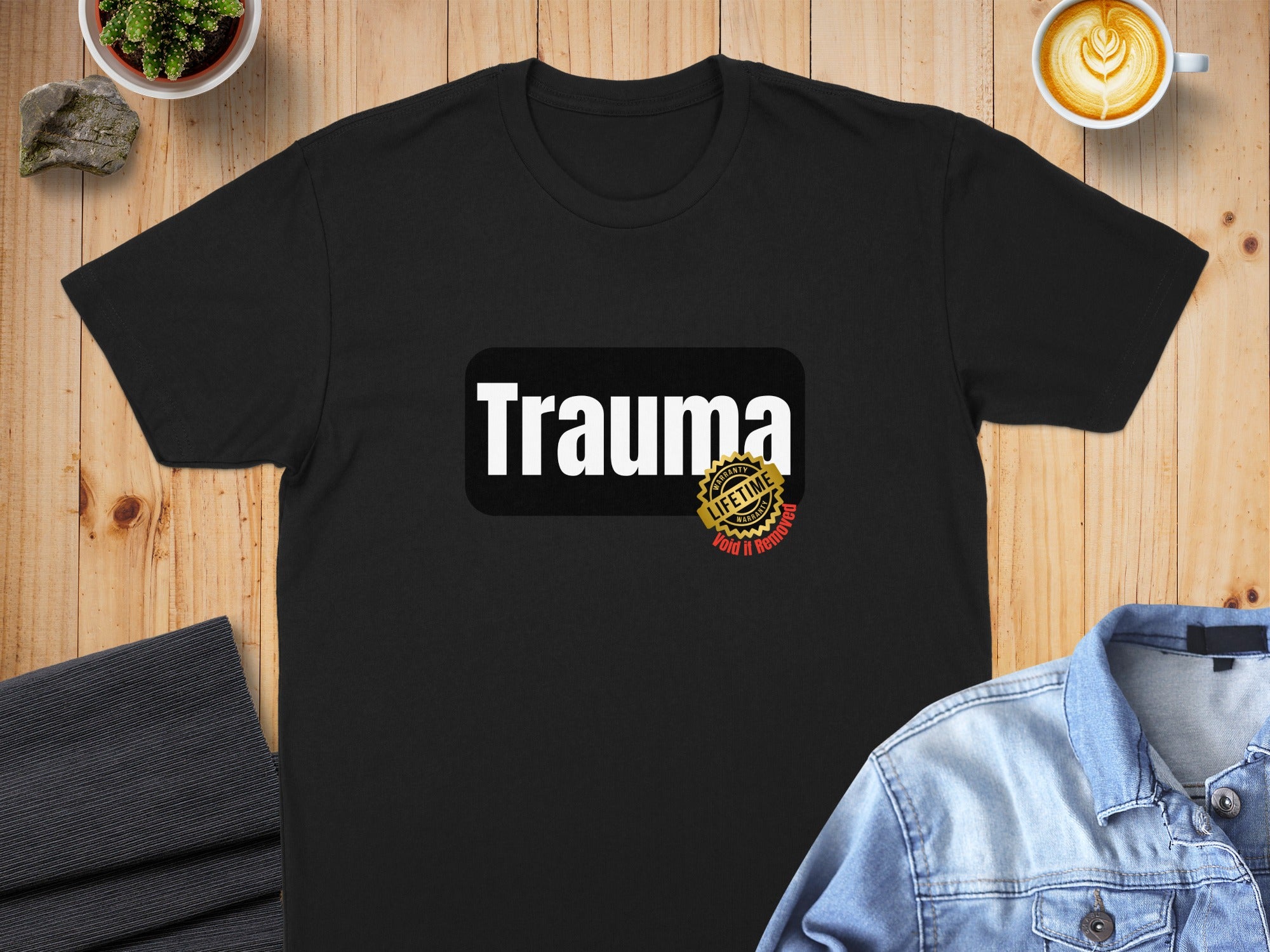 Black t-shirt with "Trauma" and "Lifetime Void If Removed" seal graphic.