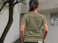 Young woman walking to a building with a phone in back pocket, wearing military green t-shirt, elements of the grind. Tactical pause apparel.