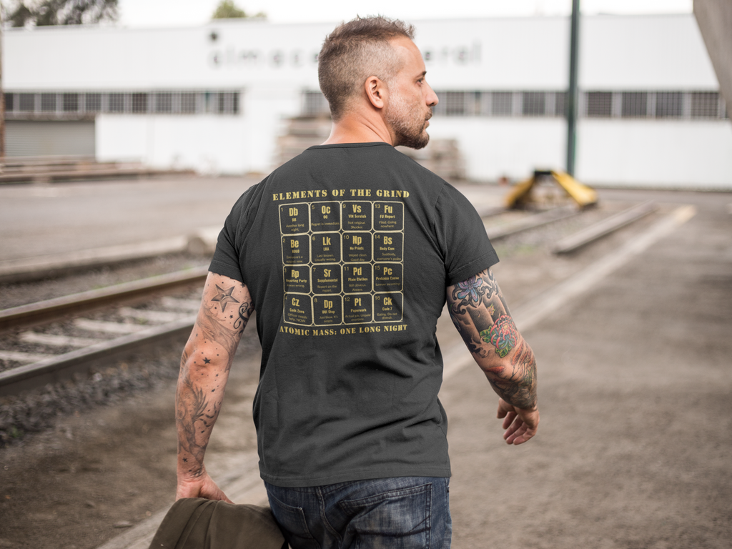 Middle-aged man walking near train tracks, wearing a black t-shirt, elements of the grind. Tactical pause apparel.
