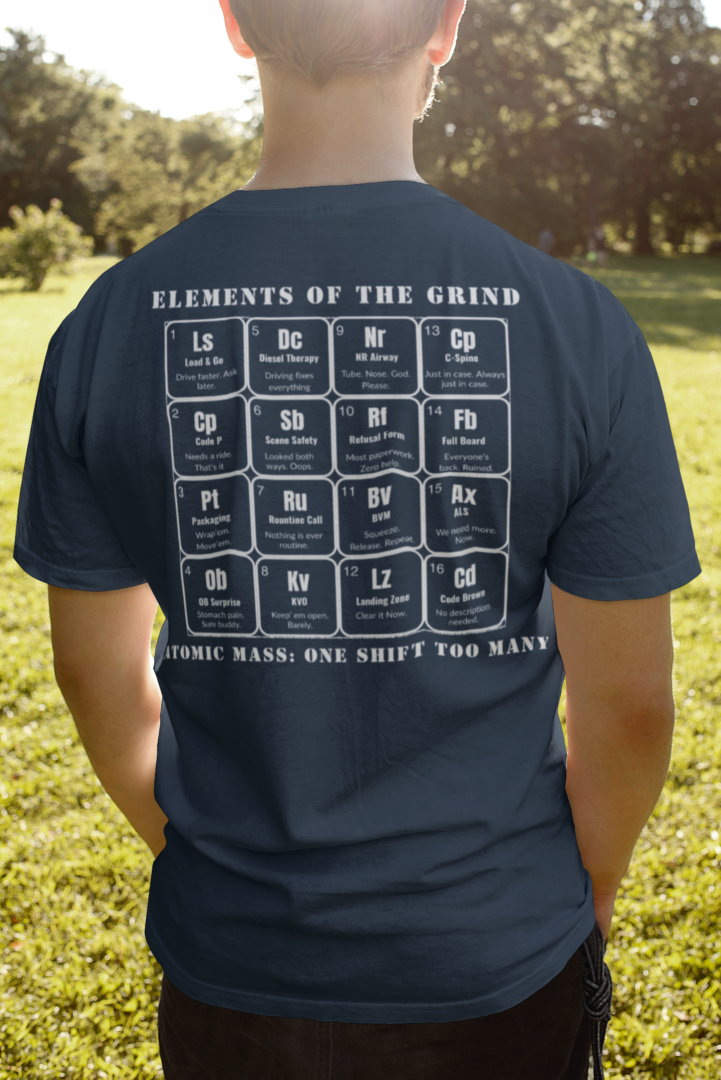 Young man on a field, facing the sun, wearing navy color t-shirt, elements of the grind. tactical pause apparel.