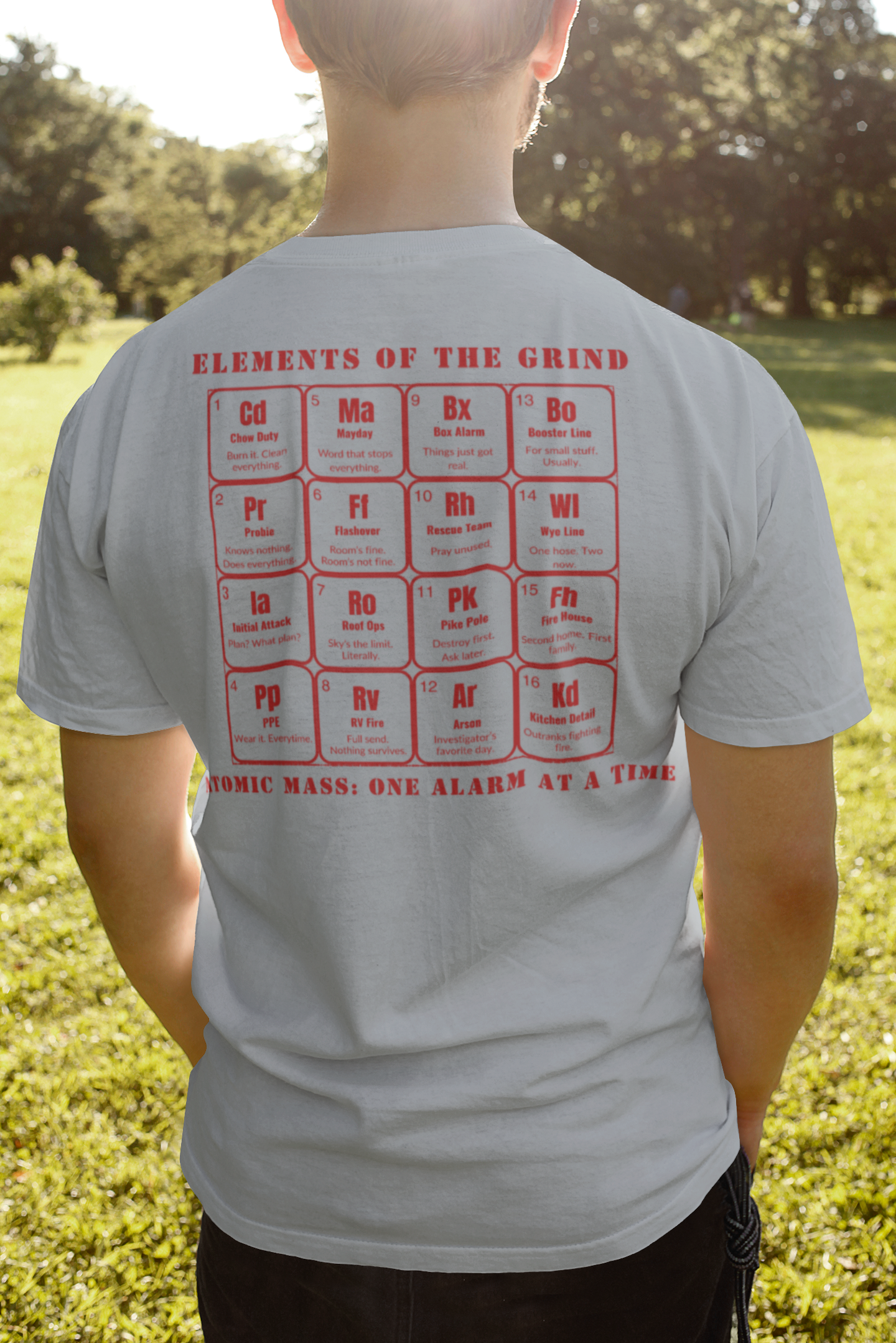Young man on a field facing the sun, wearing a heather gray t-shirt, elements of the grind. tactical pause apparel.